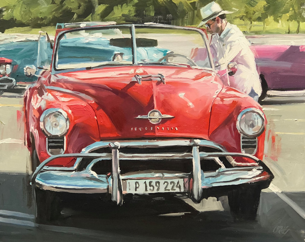 Dapper man on driver side of 1950's red convertible