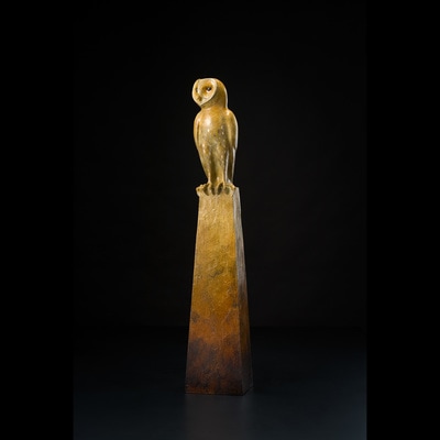 Bronze sculpture of Harlequin owl on pedestal 
