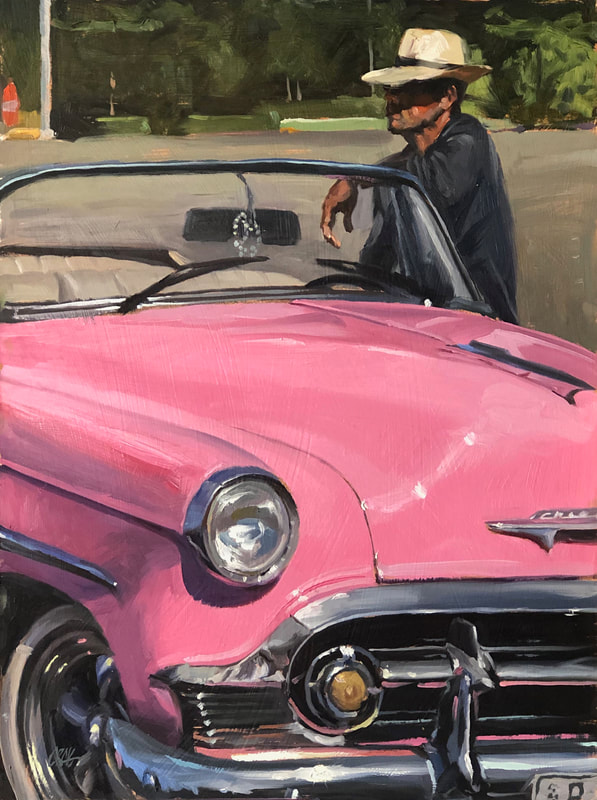 Man in brimmed hat leaning on pink 1950s Chevrolet convertible