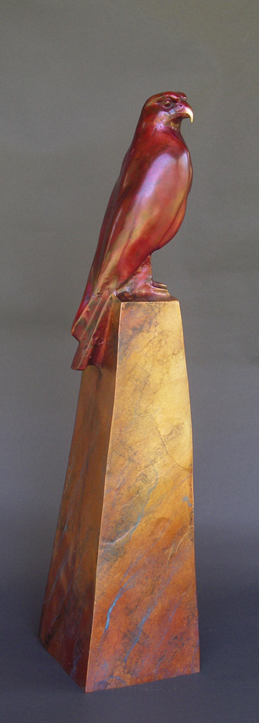 Side view of bronze sculpture of falcon on pedestal