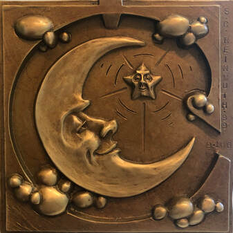 Bronze tile with crescent moon face