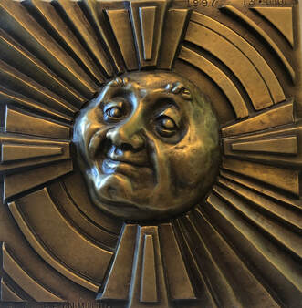 Bronze tile with sun face