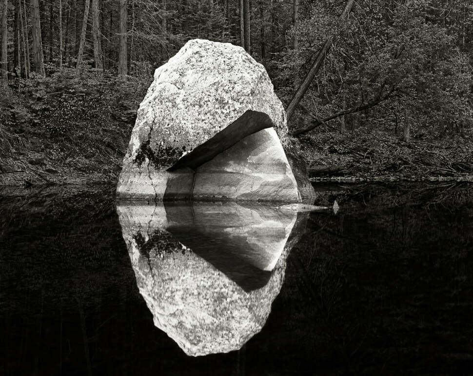 Reflection photograph of boulder in river