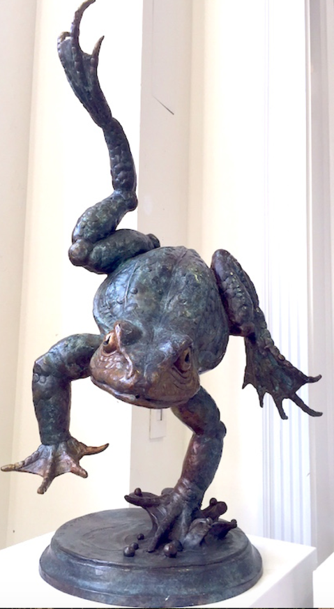 Bronze sculpture of frog in midair