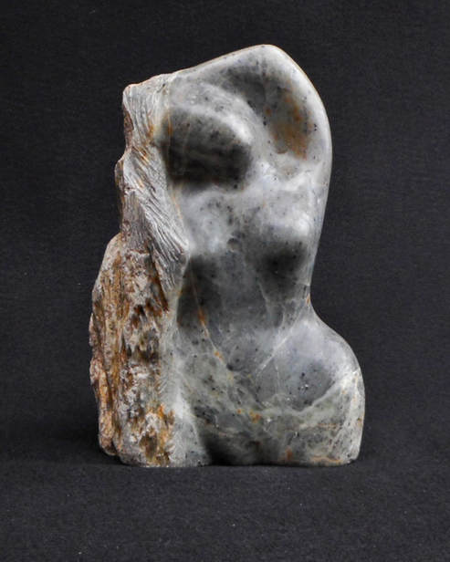 Stone carving of abstracted woman figure with long hair
