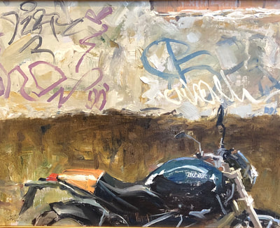 Motorcycle in front of graffiti