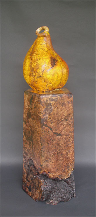 Side view of wood burl sculpture of pear on pedestal 